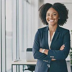 A professional woman in a navy suit smiling confidently in a modern office setting.